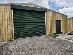 Juniper green roller shutters with automatic and fire exit door colour match
